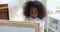 Serious African little girl drawing on white board closeup