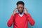 Serious afro american man in red sweater with headache in studio