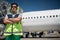 Serious airport worker with passenger plane on background