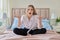 Serious anxious worried young woman sitting at home in bed