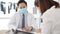 Serious Asia male doctor wear protective mask using clipboard is delivering great news talk discuss results or symptoms with