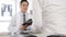 Serious Asia male doctor in white medical uniform using clipboard is delivering great news talk discuss results or symptoms with