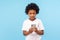 Serious attentive cute little boy with curly hair in T-shirt reading typing message on smartphone