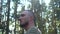 A serious bald and bearded man appears in the frame against the background of the forest. Portrait of a lumberjack