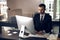 Serious bearded office clerk typing on keyboard in his office