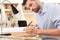 Serious bearded woodworker making drawings on lumber piece at workplace