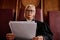 Serious blond female impartial judge reading juridical document