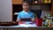 Serious Boy in Blue T-Shirt Raises Hands and Shows Black on Colored Paper