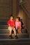 Serious boy and girl sit on stairs near door