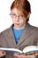 Serious boy wearing glasses with a book