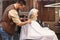 Serious brunette young man cutting hair