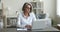 Serious business freelancer woman in glasses working at laptop