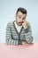 Serious business man sitting at a table on a blue background