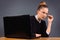 Serious business woman holds glasses and looks to the side. Office. Grey background.