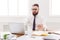 Serious businessman with laptop in modern white office