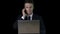 Serious businessman in suit typing on laptop, answering phone, matte effect