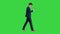 Serious businessman using phone voice dial while walking on a Green Screen, Chroma Key.