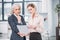 Serious businesswomen standing and holding document in office