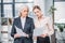 Serious businesswomen standing and holding documents in office