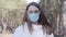 Serious caucasian girl in protective gloves and face mask putting on transparent eyeglasses. Confident young woman