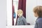 Serious Child - European blond boy tries on clothes in a store in the dressing room and looks at himself in the mirror