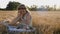 Serious child girl with long hair sits on a mown wheat field