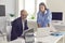 Serious company employees working on project together and studying information on laptop screen