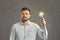 Serious confident adult caucasian man holding illuminated light bulb studio shot