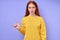 serious confident redhead woman in yellow stylish sweater demonstrating letter Y