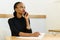 Serious confident young African or black American business woman on phone looking away with notepad in office
