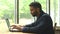 Serious confident young indian man entrepreneur in formal suit working on a laptop