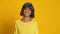 Serious dark skinned woman nods her head and says yes on yellow background
