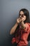 Serious determined woman aiming with a shower nozzle, blurred, focus on a tip