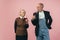 Serious elderly man and woman in retro vintage farmer outfits isolated on pink studio background. Retro style