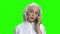 Serious elderly woman talking on phone.