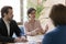 Serious engaged business leader woman talking to colleagues on meeting