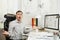 Serious and engrossed business man in shirt sitting at the desk, working at computer with modern monitor. Manager or worker.