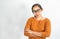 Serious face Asian woman waring orange shirt and eyeglasses; Standing and crossing one`s arm  on a white background