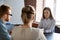 Serious female boss listening to employees reporting about work