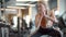 Serious fitness woman making squats at gym. Sporty girl warming up in sport club