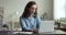 Serious freelance woman in stylish glasses sitting at laptop