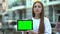 Serious girl holding green screen tablet, online courses, free trial lesson