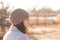 A serious girl in a knitted hat stands against a background and a coat against the backdrop of an autumn pale river landscape