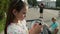 Serious girl playing on mobile phone in park. Cute girl using phone outside