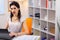 Serious good-looking young woman with red lips sitting in her office