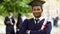 Serious graduate crossing arms with diploma in hand, completion of studies pride