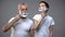 Serious granddad and grandson shaving kid pretending to be adult, morning ritual