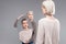 Serious grey-haired mother with red lipstick on proposing mirror