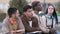 Serious group of students sitting and chatting relaxed together outdoors