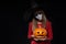 Serious Halloween witch holding Jack O`Lantern pumpkin looking at camera